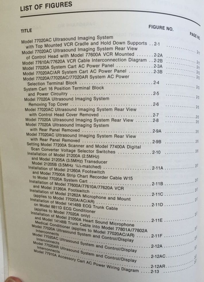 a hand holding a book with a list of figures on it