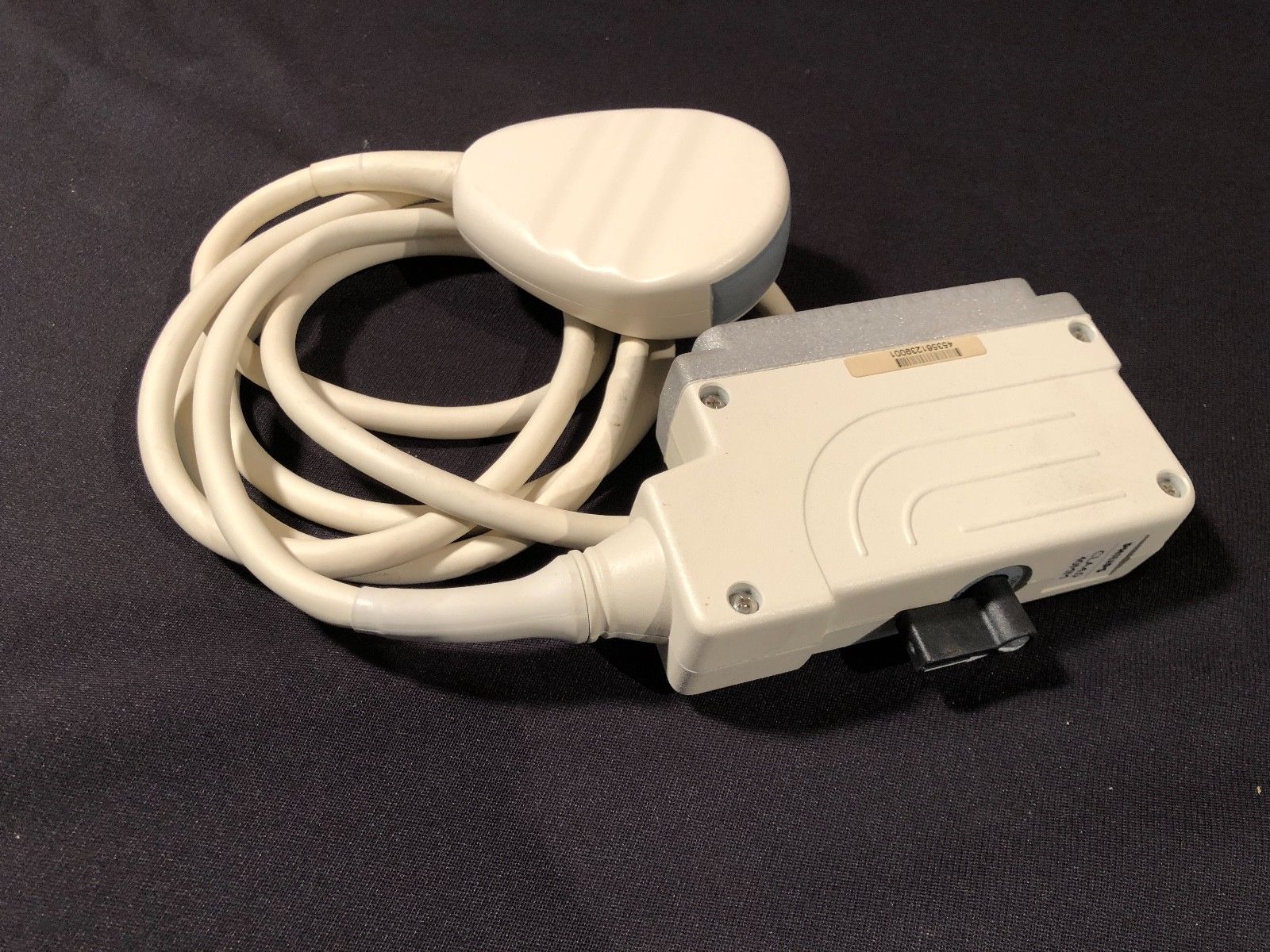 a white probe connected to a device on a black surface