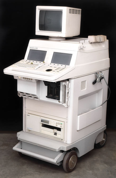 a white computer sitting on top of a cart