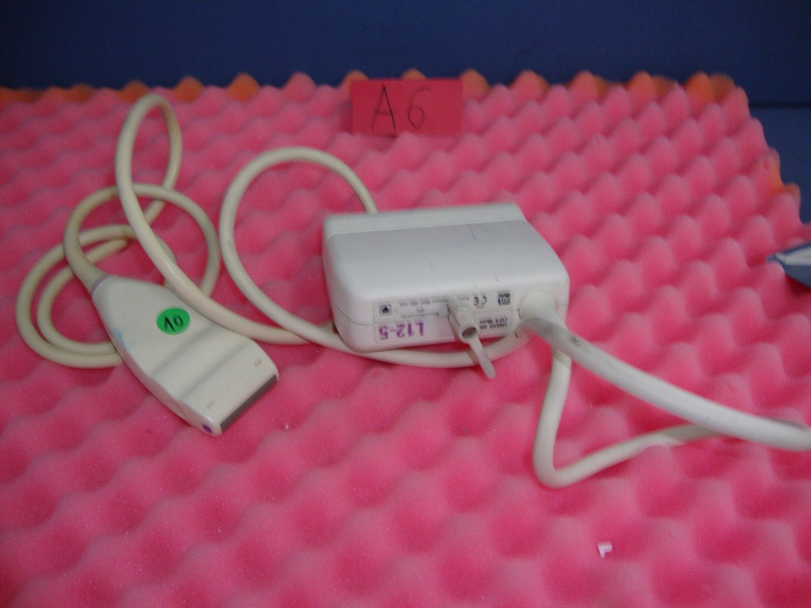 a white probe  on a pink surface