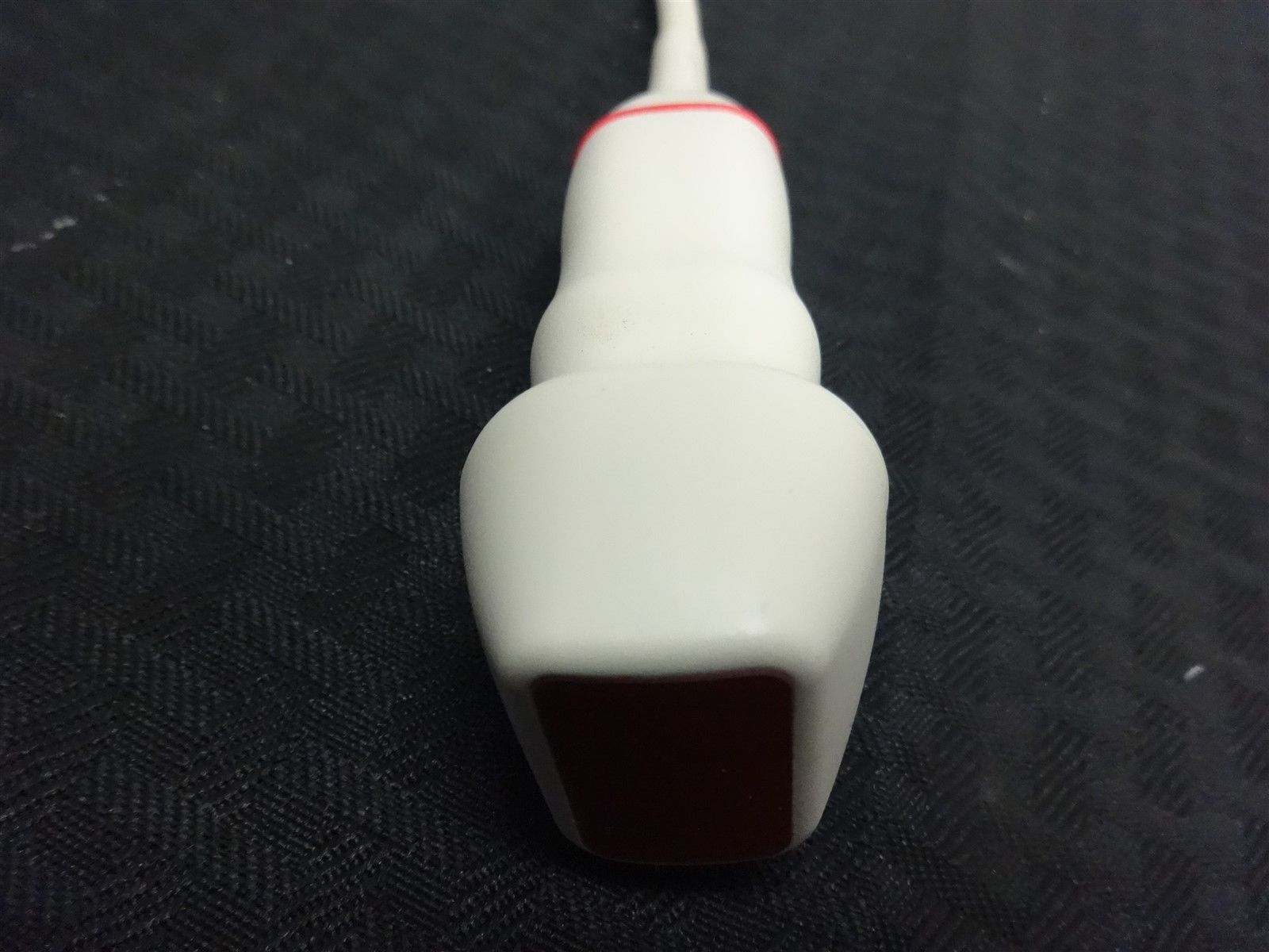 a close up of a white and red object on a black surface