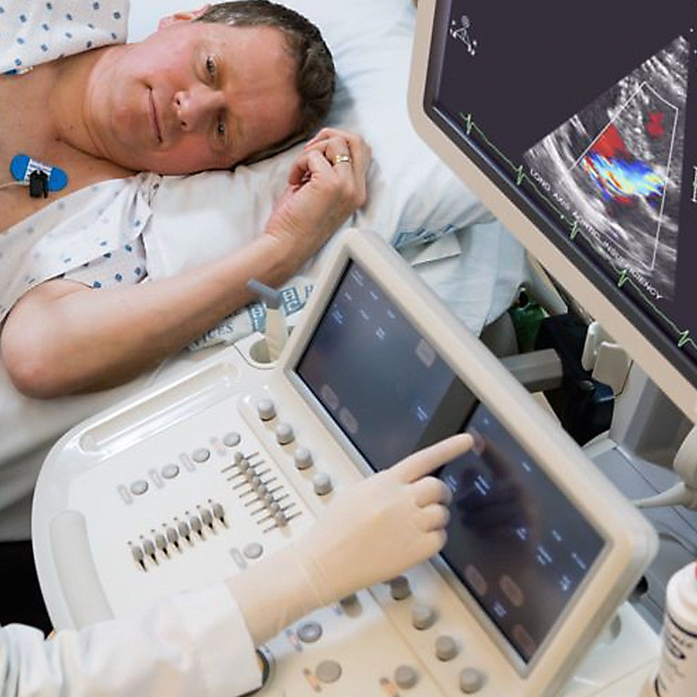 a man laying in a hospital bed next to a monitor